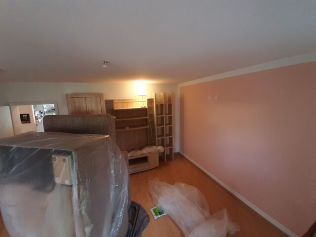 Zimmer mit frisch gestrichener Wand, Möbel noch abgedeckt